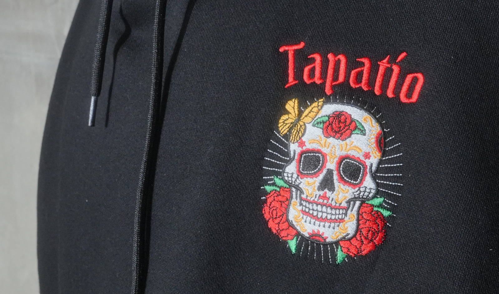 Black hoodie with a colorful skull design and 'Tapatio' text on a gray background